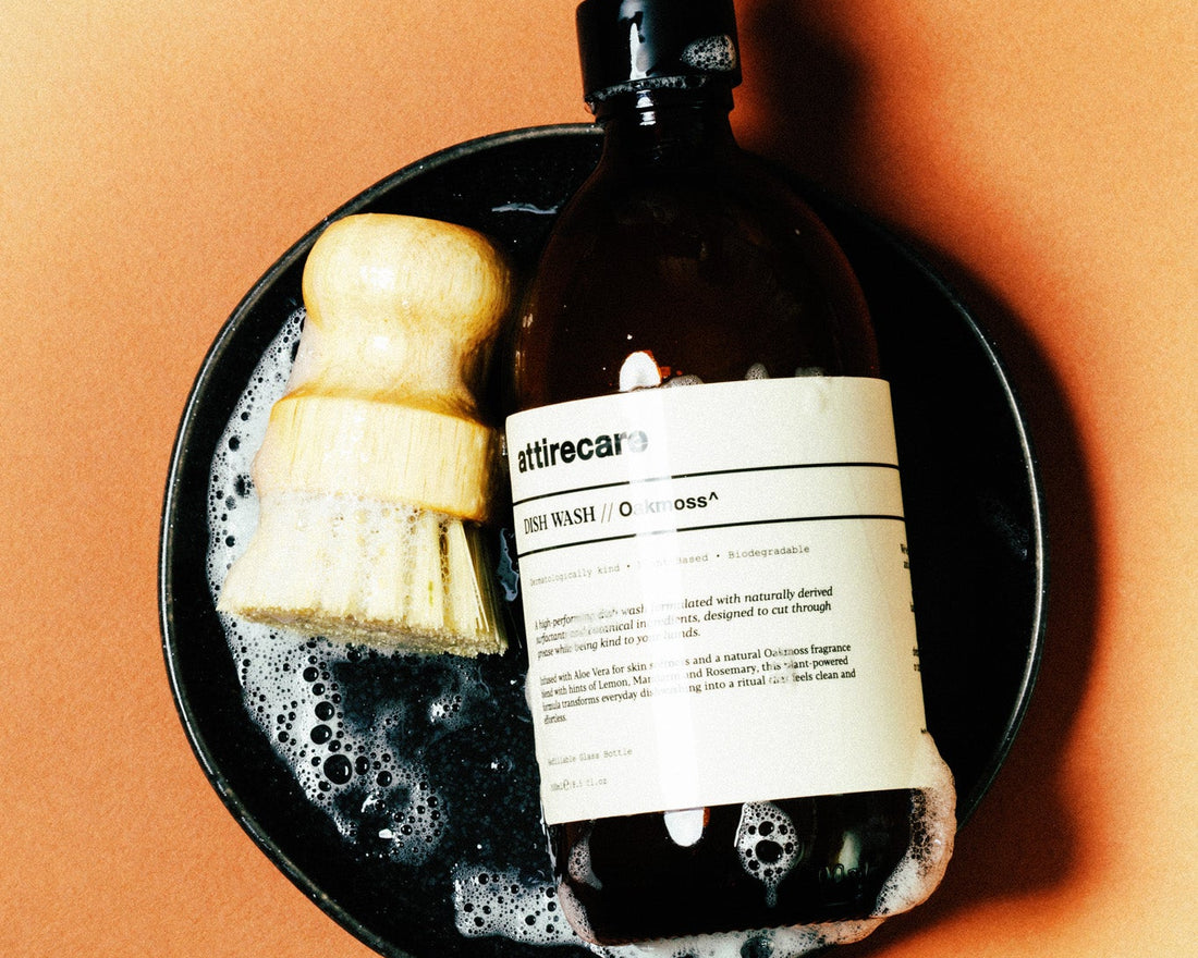 Attirecare Dish Wash Oakmoss with a natural brush in a bowl of soap bubbles