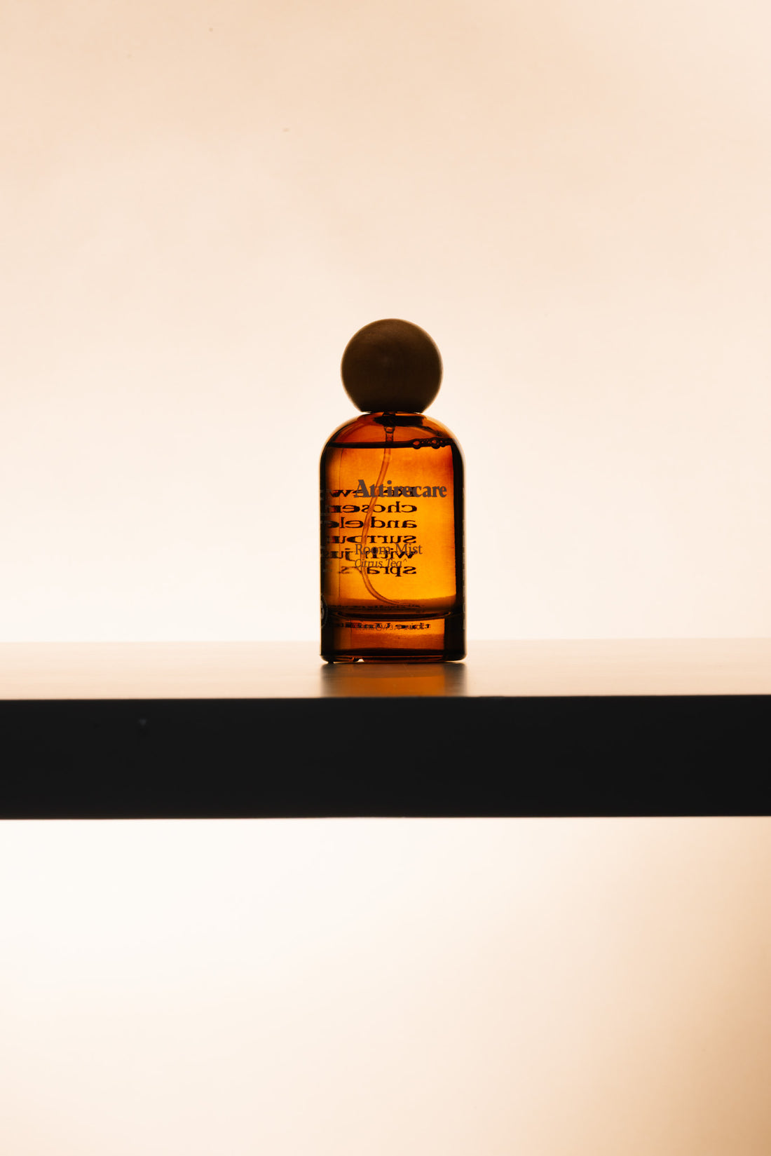 Attirecare amber Room Mist bottle in warm natural light