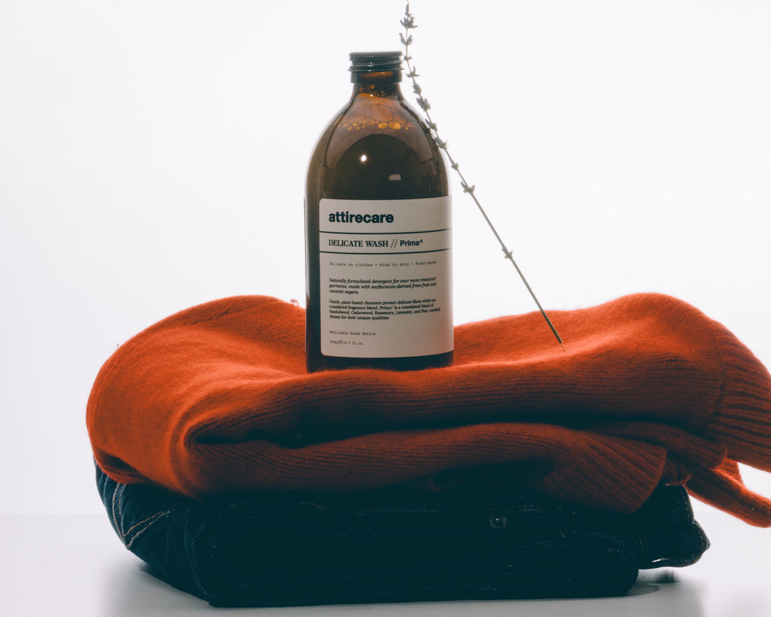 Attirecare Delicate Wash on a folded orange knit and denim